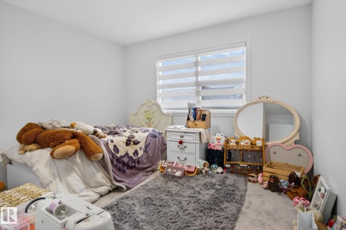 Bright room featuring a window with horizontal blinds, light gray carpet, and white walls - 7011 177 Avenue, Edmonton, AB - Indoor Photo Showing Bedroom