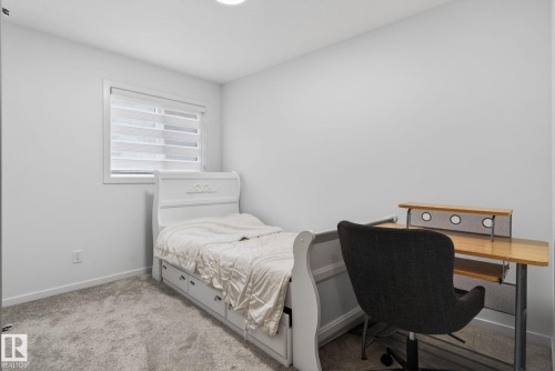 Carpeted room featuring white walls, a recessed ceiling light, and a window with horizontal blinds - 7011 177 Avenue, Edmonton, AB - Indoor Photo Showing Bedroom