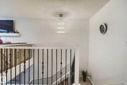 Staircase with wrought iron balusters and white handrails - 7011 177 Avenue, Edmonton, AB - Indoor Photo Showing Other Room