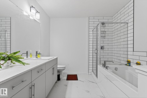 Contemporary bathroom featuring a double vanity with light gray cabinetry and a light-colored countertop - 7011 177 Avenue, Edmonton, AB - Indoor Photo Showing Bathroom