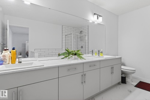 Dual vanity featuring light gray cabinetry, integrated sinks, and polished chrome faucets - 7011 177 Avenue, Edmonton, AB - Indoor Photo Showing Bathroom