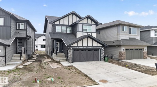 Two-story residence featuring a dark gray and light gray siding exterior with stone accents and dark trim - 7011 177 Avenue, Edmonton, AB - Outdoor With Facade