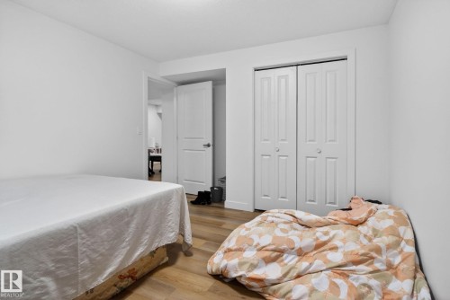 Room featuring wood-finish flooring, white walls, and a ceiling light fixture - 7011 177 Avenue, Edmonton, AB - Indoor Photo Showing Bedroom
