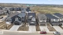 Contemporary residential development featuring a variety of architectural styles, paved driveways, and attached garages - 7011 177 Avenue, Edmonton, AB  - Outdoor With Facade 