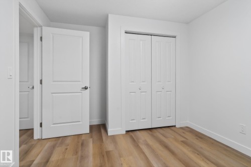 Bright interior room featuring wood-finish flooring, white walls, and white trim - 7011 177 Avenue, Edmonton, AB - Indoor