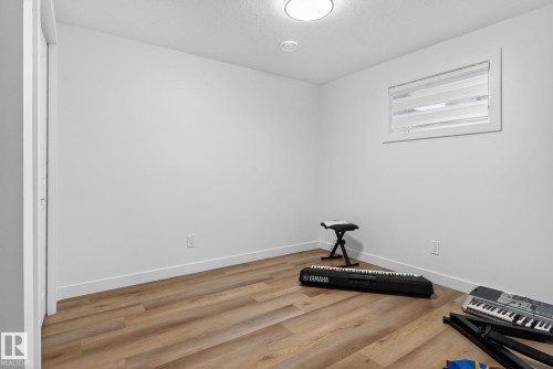 Room featuring wood-finish flooring, white baseboards, and neutral wall paint - 7011 177 Avenue, Edmonton, AB - Indoor