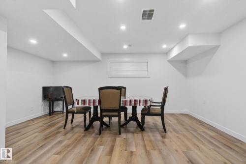 Spacious room featuring wood-finish flooring, recessed lighting, and a window with blinds - 7011 177 Avenue, Edmonton, AB - Indoor