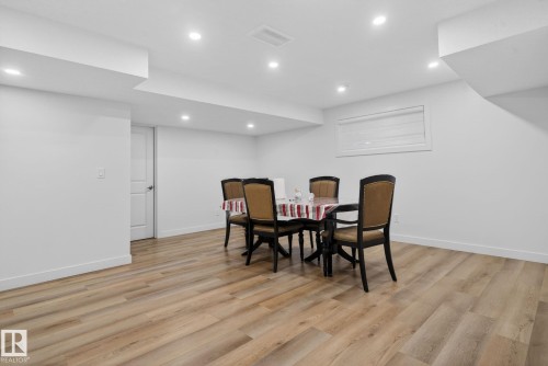 Spacious room featuring light wood-finish flooring and recessed ceiling lighting - 7011 177 Avenue, Edmonton, AB - Indoor Photo Showing Other Room