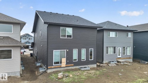 Rear exterior featuring dark gray horizontal siding and a dark shingle roof - 7011 177 Avenue, Edmonton, AB - Outdoor With Exterior