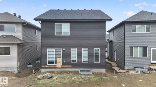 Two-story rear elevation featuring dark gray horizontal siding and a dark shingle roof - 7011 177 Avenue, Edmonton, AB - Outdoor With Exterior