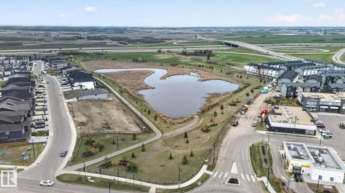 Aerial perspective showcasing a developed residential area with a central water feature, surrounded by paved pathways and green spaces - 7011 177 Avenue, Edmonton, AB - Outdoor With View