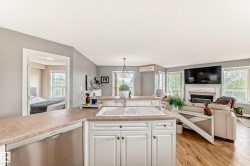 Open-concept kitchen featuring laminate countertops, white cabinetry, and a stainless steel dishwasher - 