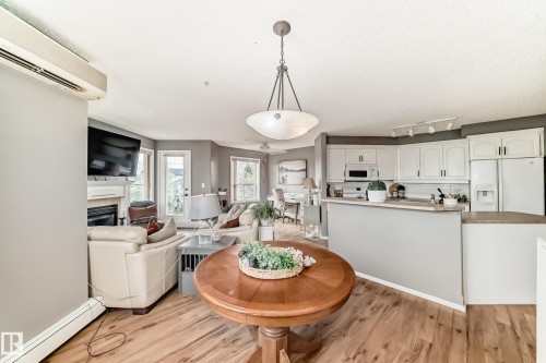 Open-concept main living area with wood-finish flooring - 331 9704 174 Street, Edmonton, AB - Indoor With Fireplace