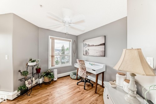 Room featuring wood-finish flooring, a white trim window, and neutral-toned walls - 331 9704 174 Street, Edmonton, AB - Indoor