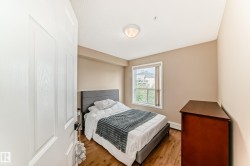 Bedroom featuring neutral-toned walls and wood-finish flooring - 