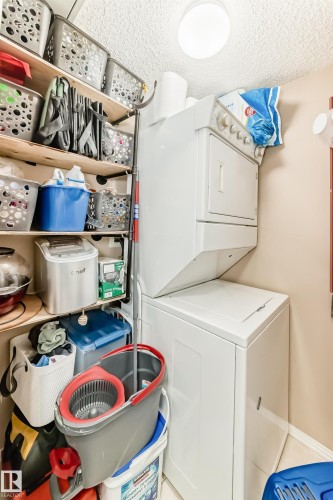 Dedicated utility area featuring a stackable washer and dryer - 331 9704 174 Street, Edmonton, AB - Indoor Photo Showing Laundry Room