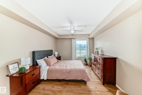 Bedroom featuring wood-finish flooring, a tray ceiling, and a ceiling fan - 331 9704 174 Street, Edmonton, AB - Indoor Photo Showing Bedroom