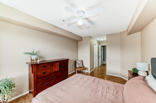 Spacious room with wood-finish flooring, a white ceiling fan with light fixture, and neutral wall tones - 331 9704 174 Street, Edmonton, AB - Indoor Photo Showing Bedroom