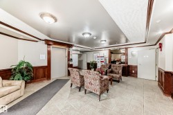 Lobby area featuring wood-paneled wainscoting, decorative crown molding, and tiled flooring - 
