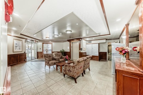 Spacious lobby featuring tile flooring, wainscoting, decorative crown molding, and recessed lighting - 331 9704 174 Street, Edmonton, AB - Indoor Photo Showing Other Room