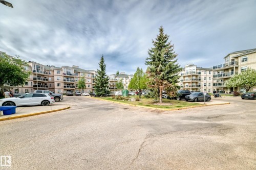Expansive multi-story apartment buildings featuring balconies and a central parking area - 331 9704 174 Street, Edmonton, AB - Outdoor