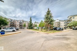Expansive multi-story apartment buildings featuring balconies and a central parking area - 