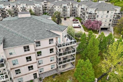 Multi-story residential building featuring a light-toned exterior finish and numerous balconies with glass railings - 331 9704 174 Street, Edmonton, AB - Outdoor