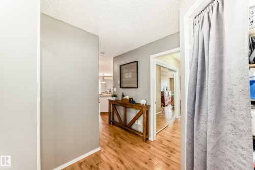 Hallway with wood-finish flooring, light grey painted walls, and white trim - 331 9704 174 Street, Edmonton, AB - Indoor