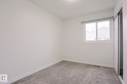 Bright interior space featuring a window with white trim, roller shades, and patterned carpet flooring - 