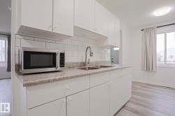 Modern kitchen featuring white cabinetry and a subway tile backsplash - 