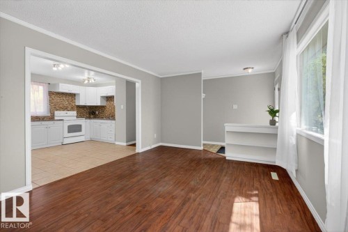 Open-concept living space featuring wood-finish flooring and light gray walls - 4630 114 Avenue, Edmonton, AB - Indoor Photo Showing Kitchen