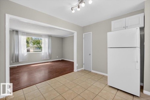 Kitchen area featuring tiled flooring and a white refrigerator - 4630 114 Avenue, Edmonton, AB - Indoor