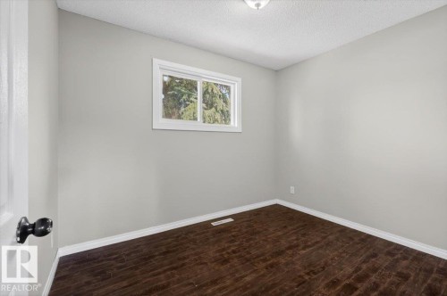 Interior room featuring dark wood-finish flooring, light grey painted walls, and white baseboards - 4630 114 Avenue, Edmonton, AB - Indoor Photo Showing Other Room