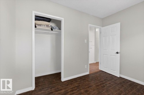 Room featuring wood-finish flooring, light grey wall paint, and white baseboards - 4630 114 Avenue, Edmonton, AB - Indoor Photo Showing Other Room