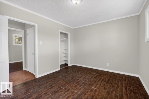 Spacious room featuring rich wood-finish flooring, light gray wall tones, and crisp white trim - 4630 114 Avenue, Edmonton, AB - Indoor Photo Showing Other Room