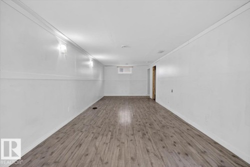 Expansive room featuring wood-finish flooring, white walls, and recessed lighting - 4630 114 Avenue, Edmonton, AB - Indoor Photo Showing Other Room