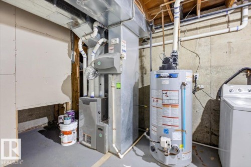 Dedicated utility area featuring a water heater, furnace, and laundry appliances - 4630 114 Avenue, Edmonton, AB - Indoor Photo Showing Basement
