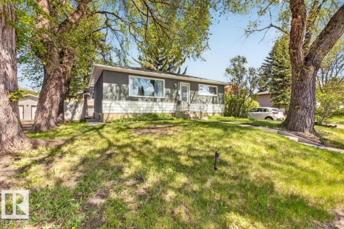 Exterior featuring dark gray siding, white horizontal paneling, a front entry with a storm door, and a large picture window - 4630 114 Avenue, Edmonton, AB - Outdoor