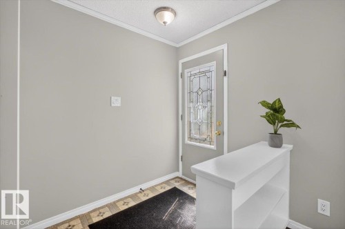 Entryway featuring a decorative glass panel door, light gray wall paint, and patterned tile flooring - 4630 114 Avenue, Edmonton, AB - Indoor Photo Showing Other Room