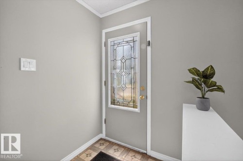 Entryway featuring a grey painted door with decorative leaded glass, brass door hardware, and a white trim frame - 4630 114 Avenue, Edmonton, AB - Indoor Photo Showing Other Room