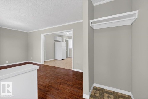 Living area with wood-finish flooring and light gray walls - 4630 114 Avenue, Edmonton, AB - Indoor Photo Showing Other Room