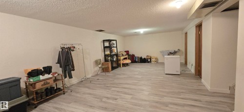 Spacious interior room featuring light-toned wood-finish flooring, white painted walls, recessed lighting, and two light wood-paneled doors - 5113 45 B Avenue, Vegreville, AB - Indoor Photo Showing Other Room