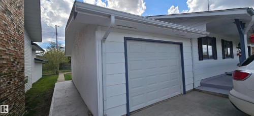 Attached single-car garage with a paneled door and dark trim - 5113 45 B Avenue, Vegreville, AB - Outdoor With Exterior