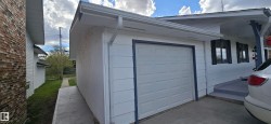 Attached single-car garage with a paneled door and dark trim - 