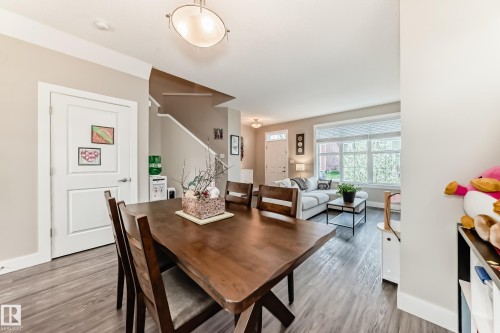 Expansive dining area featuring wood-finish flooring and a contemporary overhead light fixture - 2125 24 Street, Edmonton, AB - Indoor Photo Showing Dining Room