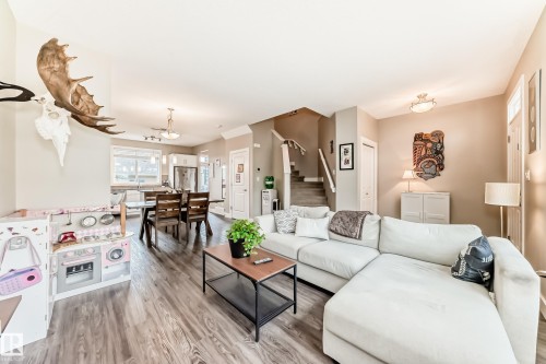 Spacious living area featuring wood-finish flooring, a neutral color palette, and ceiling-mounted lighting fixtures - 2125 24 Street, Edmonton, AB - Indoor Photo Showing Living Room