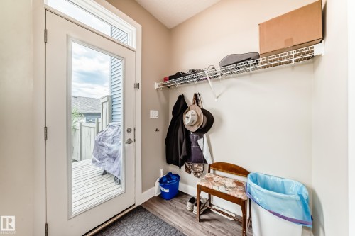 Rear entrance featuring a full-light door with transom window, wood-finish flooring, and a wire shelving system - 2125 24 Street, Edmonton, AB - Indoor