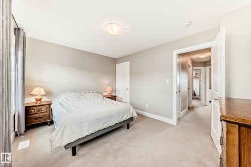 Carpeted room with a neutral wall palette, white trim, and a ceiling-mounted light fixture - 2125 24 Street, Edmonton, AB - Indoor Photo Showing Bedroom