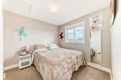 Neutral-toned carpeting extends throughout this room, featuring a white window frame with multiple panes - 