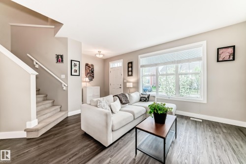 Spacious living area featuring wood-finish flooring and a large multi-pane window - 2125 24 Street, Edmonton, AB - Indoor Photo Showing Living Room
